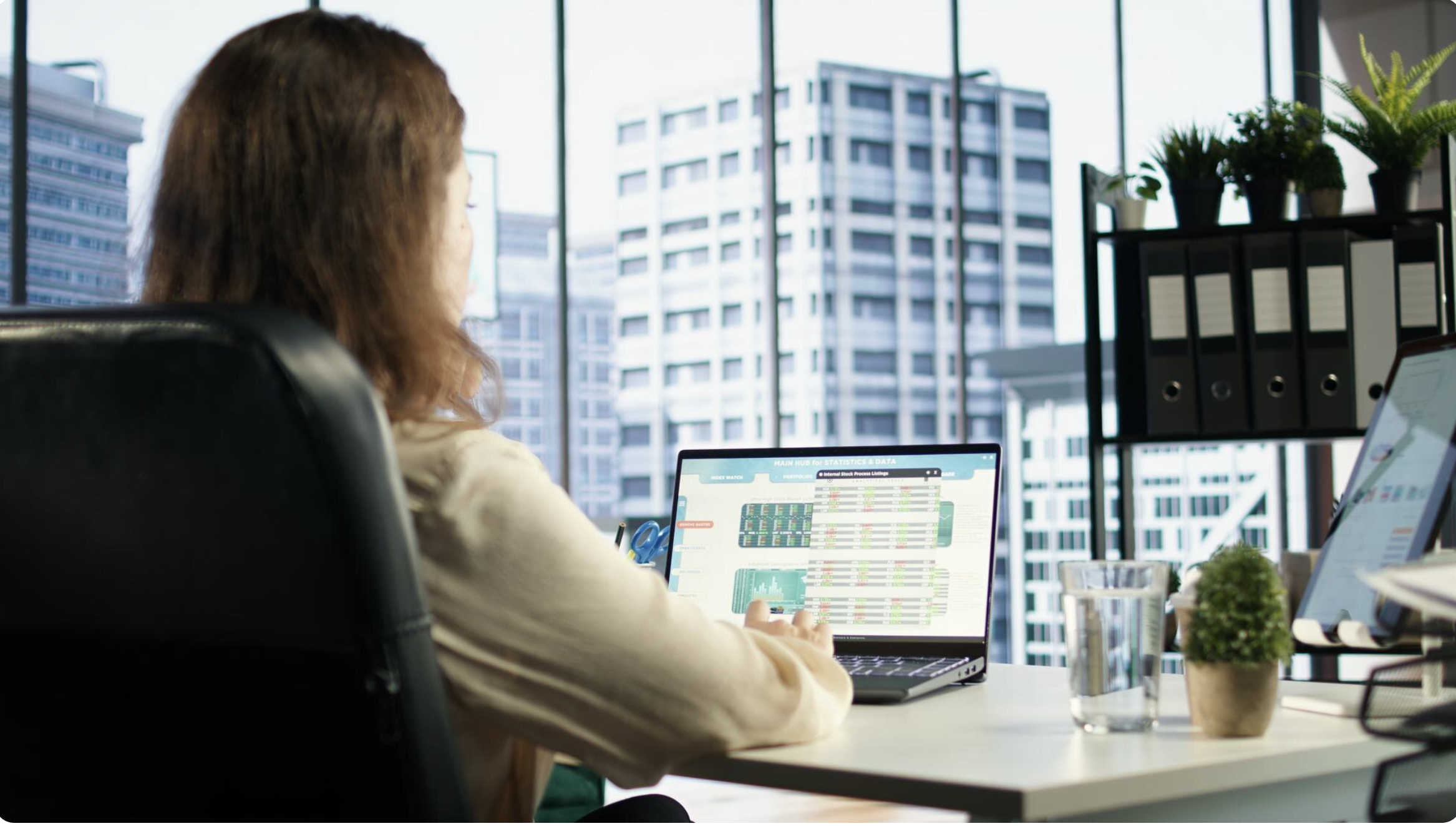 Asset manager reviewing financial performance data on laptop in modern office setting